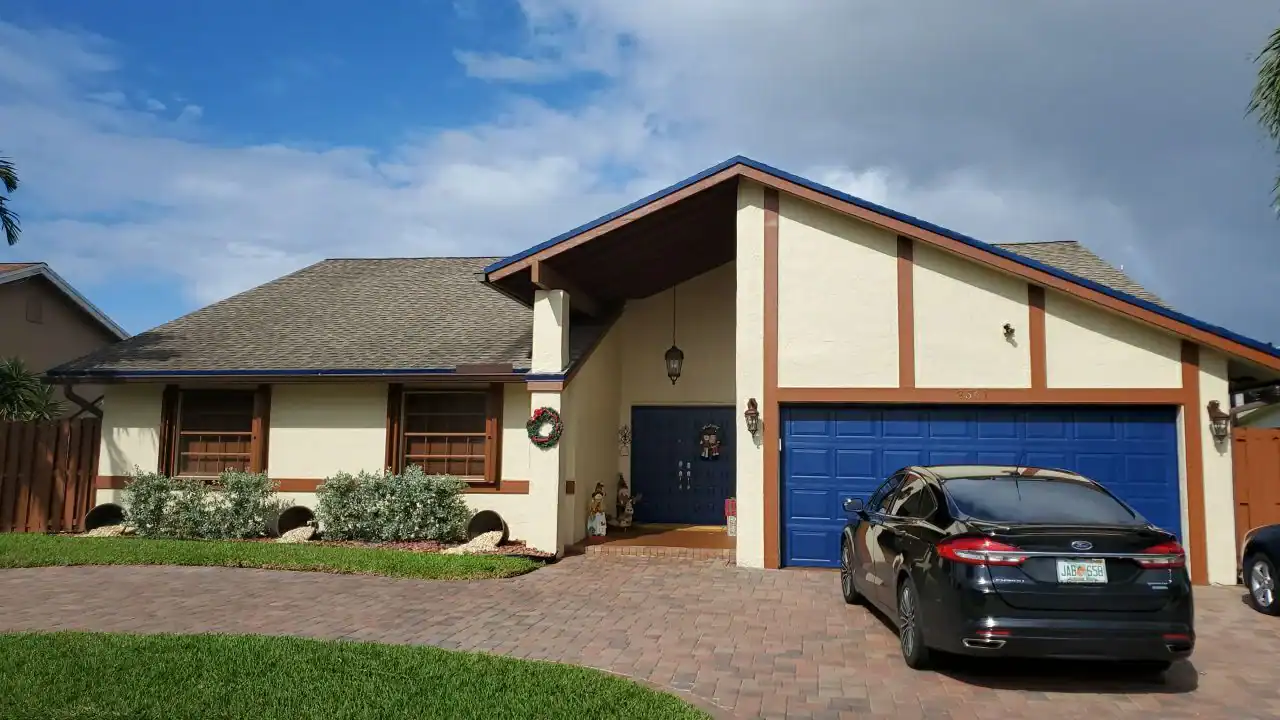 Blue garage attached to a modern house in Broward County, Florida, highlighting the property’s exterior condition and Aastro Roofing services